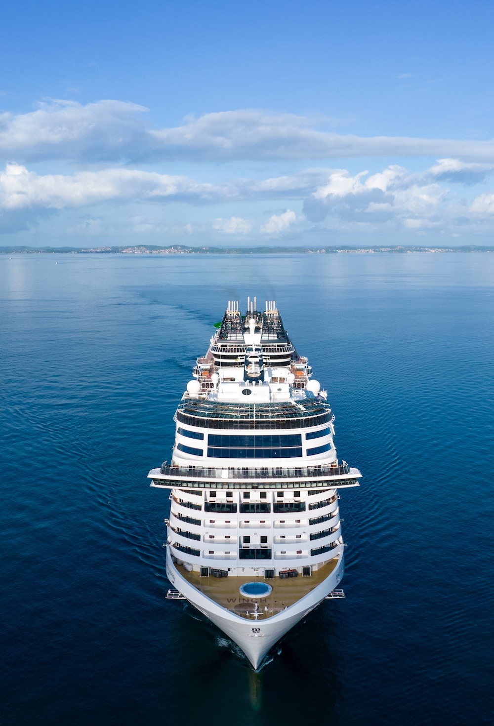 Luxurious large cruise ship sailing in calm blue waters and clear skies, Aerial view